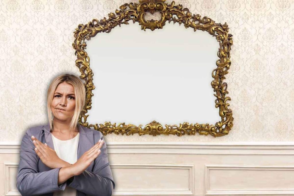 specchio antico a parete e donna che dice no