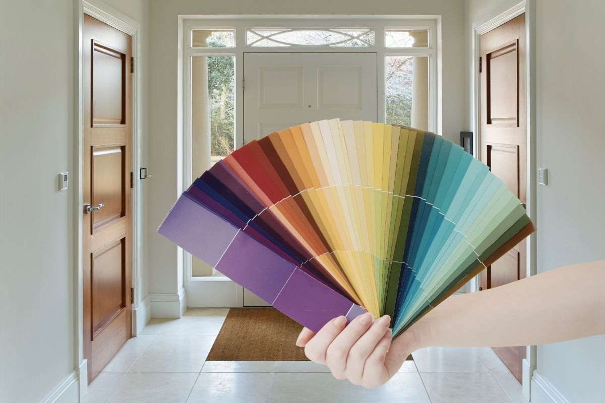 ingresso di casa e mano che mantiene una serie di colori per parete