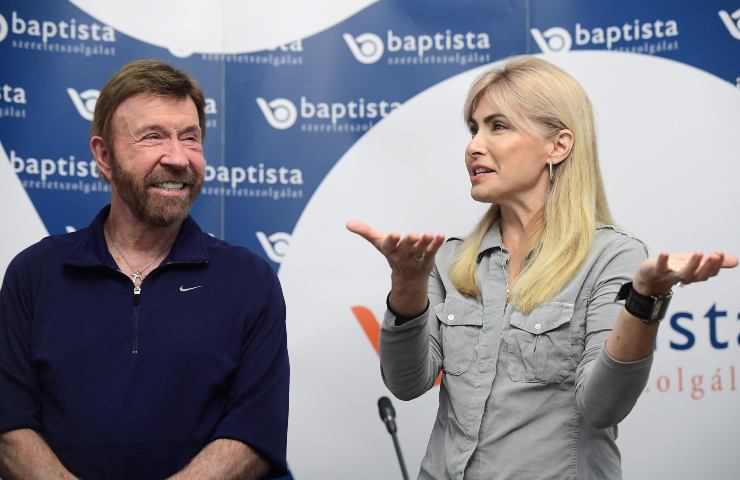 Chuck Norris sorride nel corso di un intervento pubblico accanto alla moglie Ghana O'Kelley.